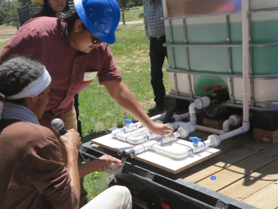 Two men working on a water tank