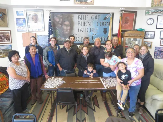 Karletta Chief and her family around a table with an unfinished jigsaw puzzle.