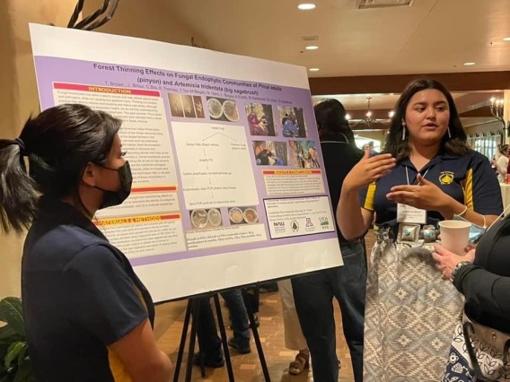 Two Dine' College students presenting research poster