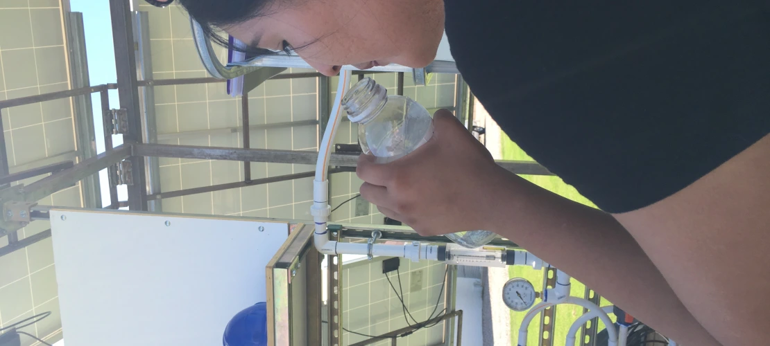 Person drinking purified water from solar nanofiltration unit