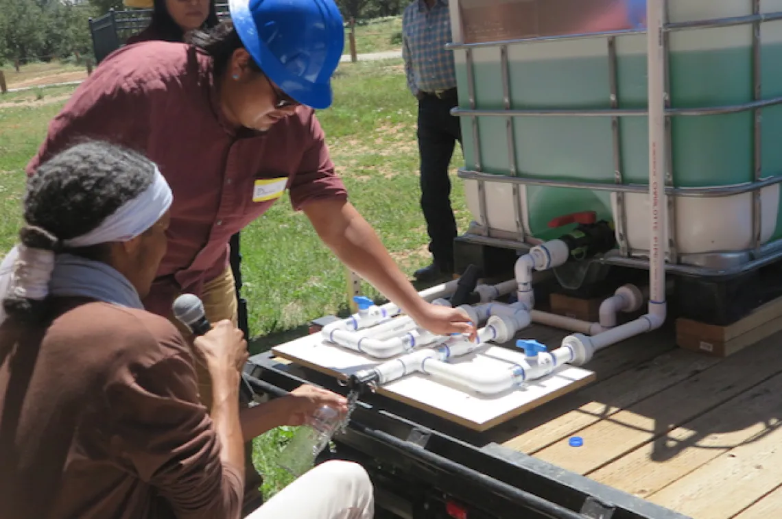 Two men working on a water tank