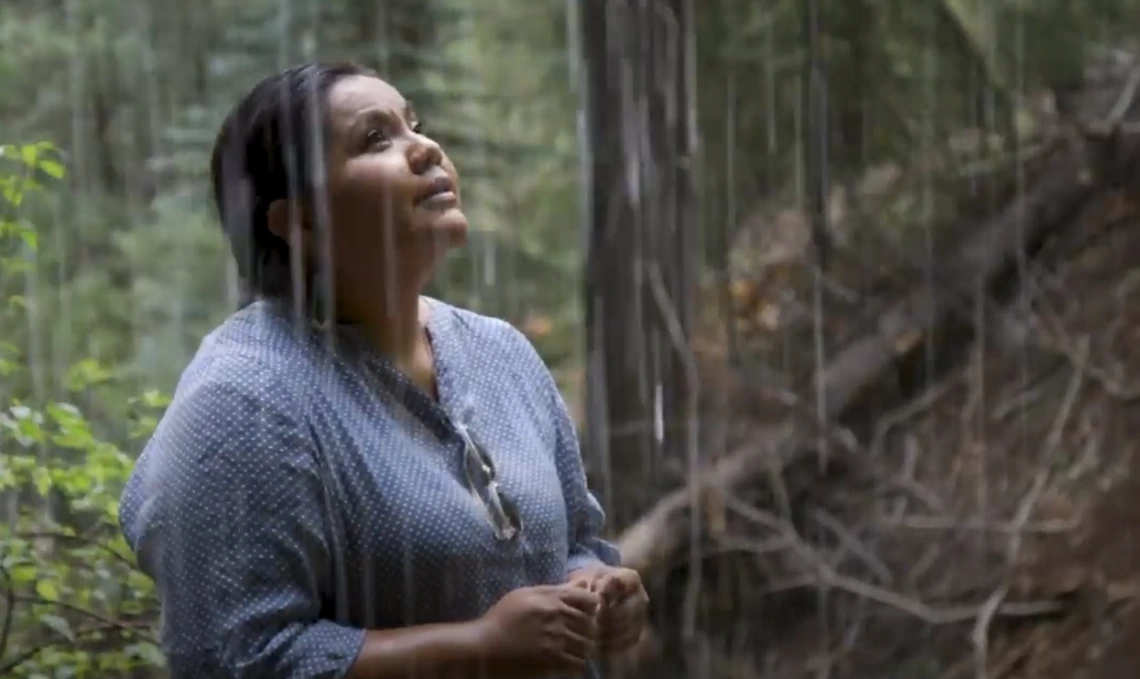 Screenshot from the video where Nikki Tulley is standing in the rain.