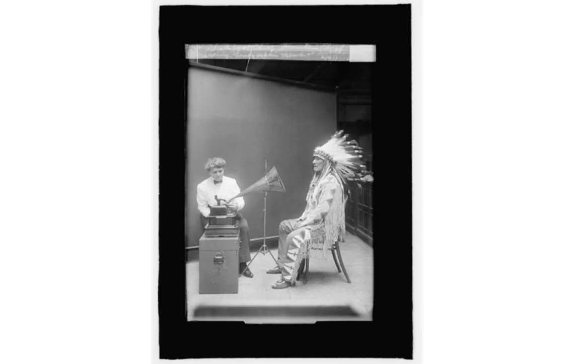 Blackfoot leader, Ninna-stako, interpreting a cylinder recording with ethnologist Frances Densmore observing