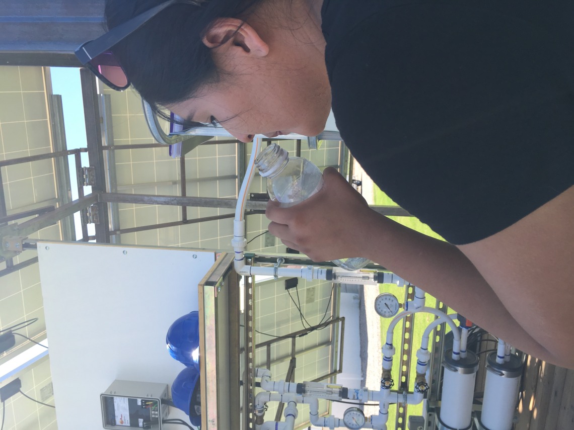 Person drinking purified water from solar nanofiltration unit