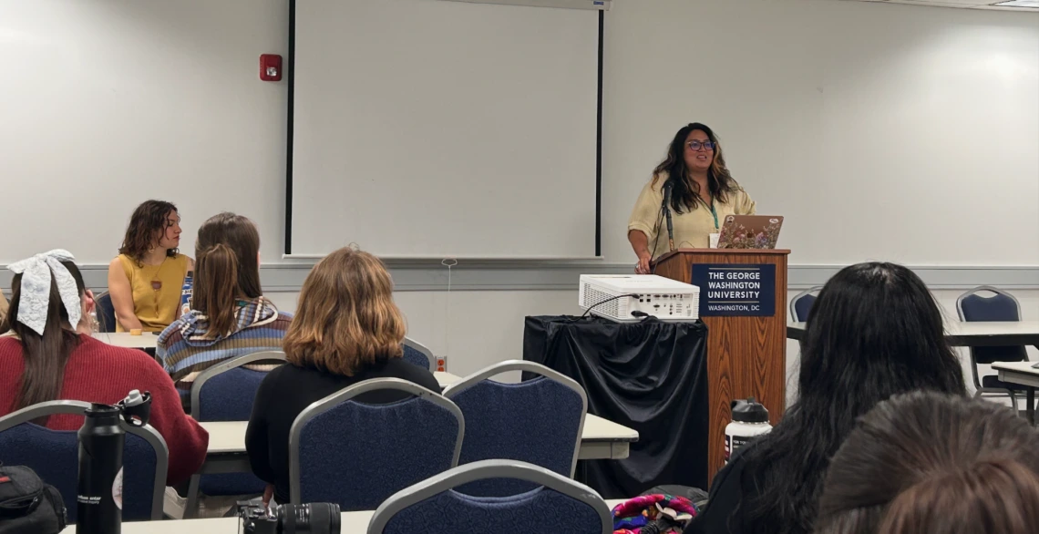 Ivey Camille Manybeads Tso and Sagen Quale in front of an audience leading a workshop.